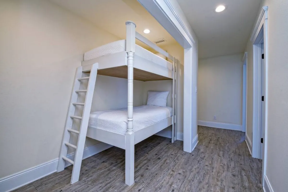 A cozy bunk bed with a sturdy ladder creates a playful yet functional sleeping area, ideal for children or friends. The compact design maximizes space and provides a fun, inviting atmosphere.