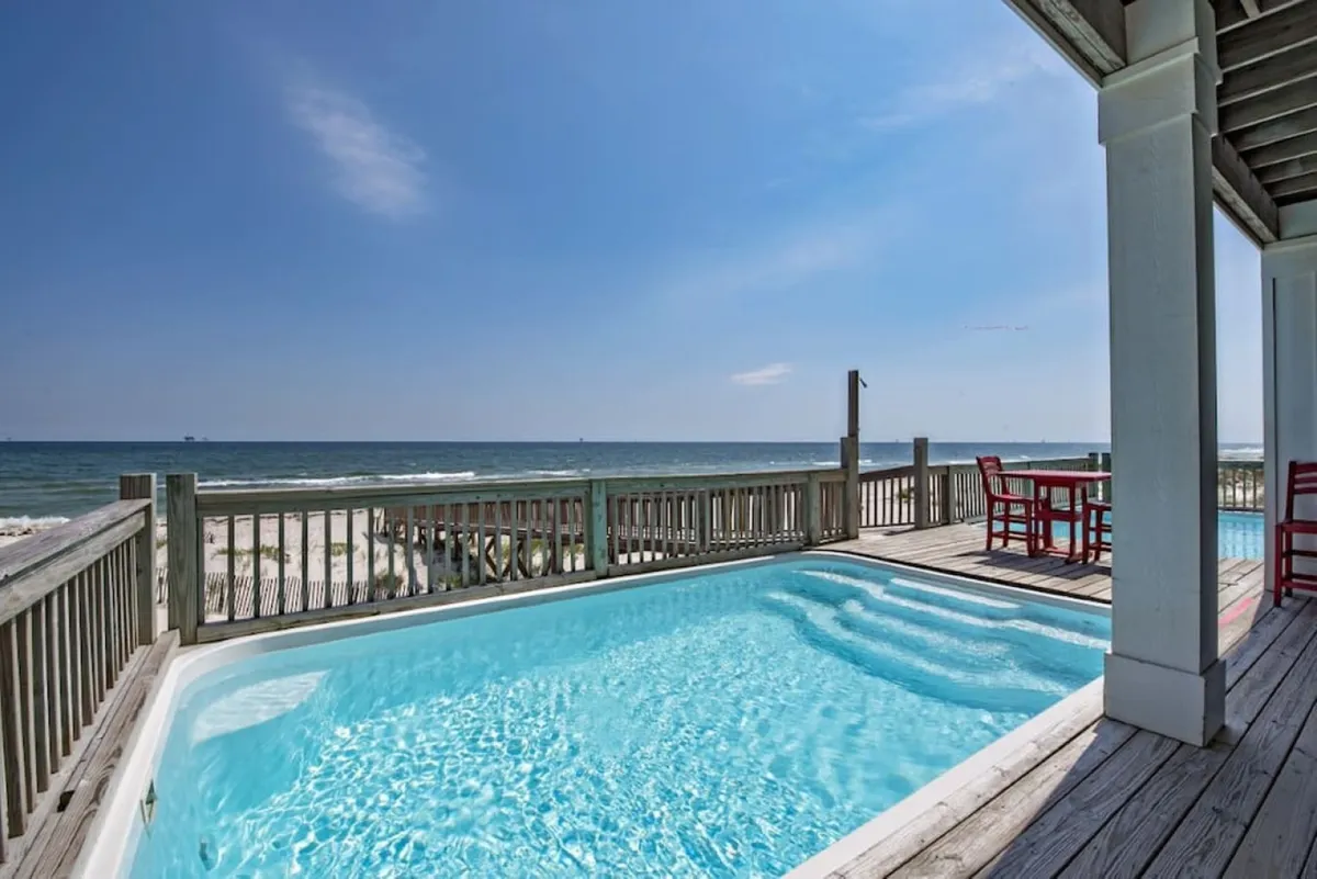 This image reveals a seamless connection from the interior to an outdoor pool and deck area with stunning ocean views. The deck is inviting for lounging, socializing, or simply enjoying the Gulf breeze, illustrating the effortless flow from indoors to outdoors described in the section.